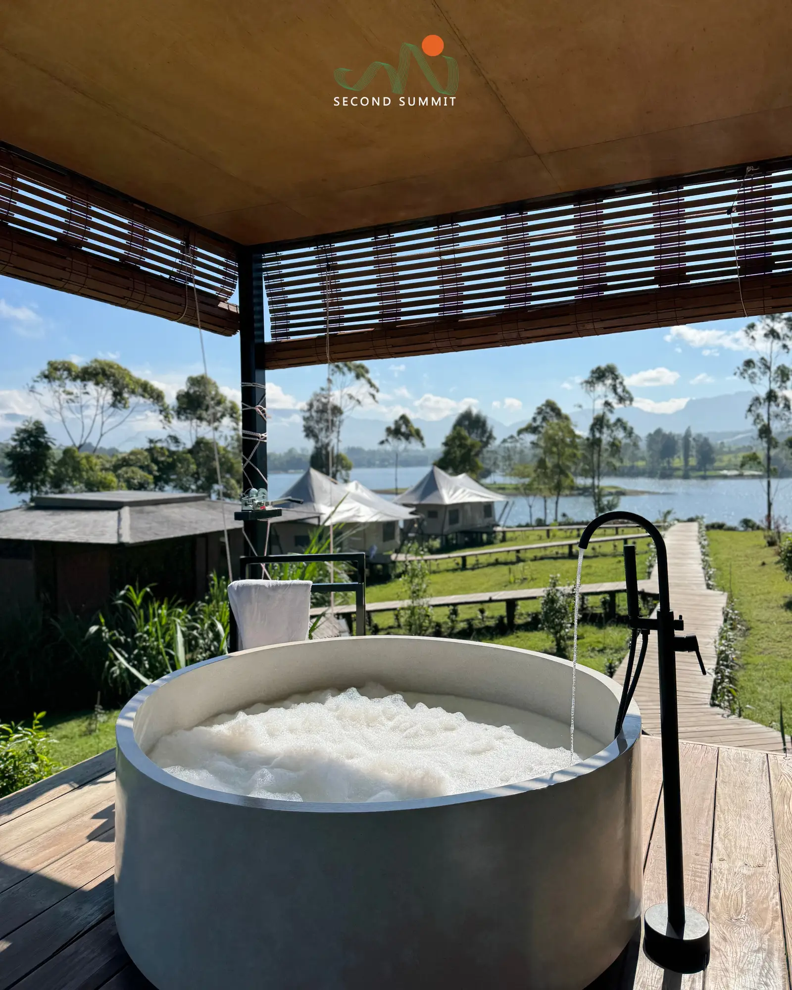 Private soaking tub on a glamping tent deck overlooking the lake
